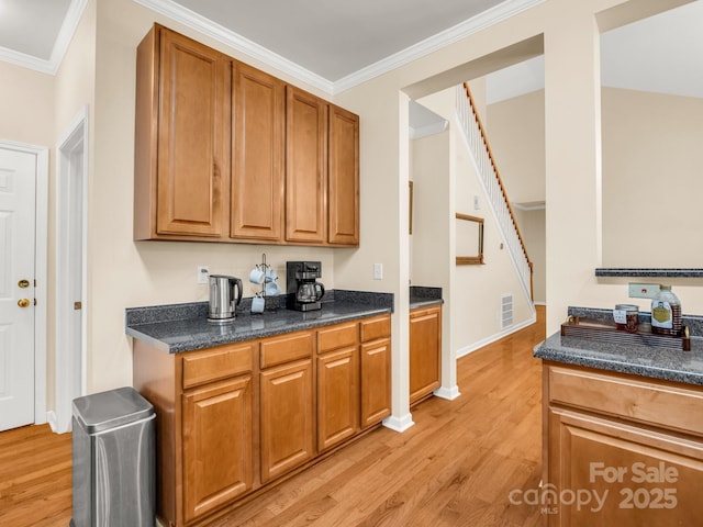 24 Yorktown Cir, Arden, NC 28704 - kitchen with crown molding, dark countertops, light wood-style flooring, and brown cabinets