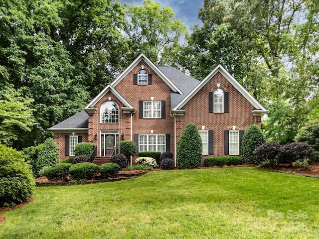 5816 Valley Stream Trl, Waxhaw, NC 28173 - traditional home with brick siding, a front yard, and roof with shingles