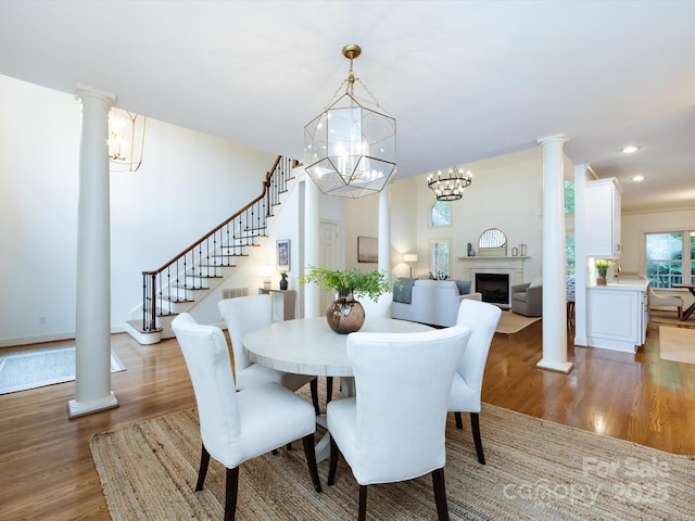 5816 Valley Stream Trl, Waxhaw, NC 28173 - dining room with wood finished floors, a chandelier, a fireplace, stairway, and recessed lighting