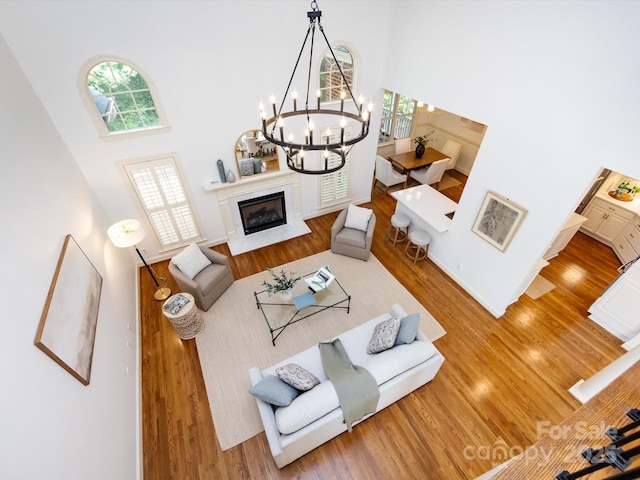 5816 Valley Stream Trl, Waxhaw, NC 28173 - living room with a high ceiling, wood finished floors, and a chandelier