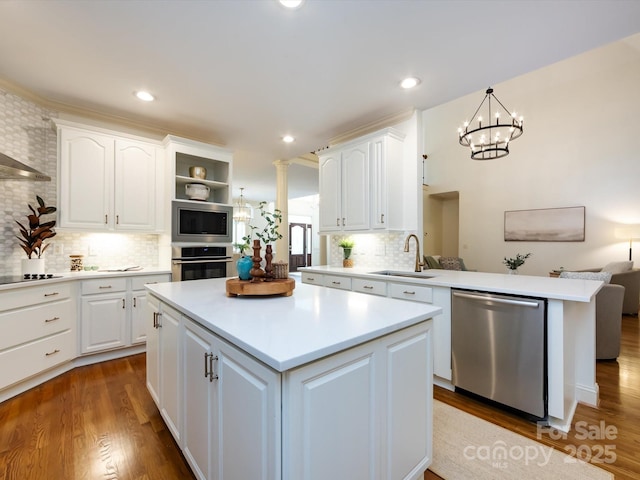 5816 Valley Stream Trl, Waxhaw, NC 28173 - kitchen featuring appliances with stainless steel finishes, a sink, a kitchen island, light countertops, and wood finished floors