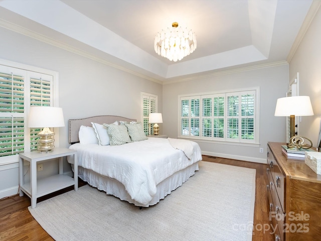 5816 Valley Stream Trl, Waxhaw, NC 28173 - bedroom with wood finished floors, a chandelier, a raised ceiling, crown molding, and baseboards