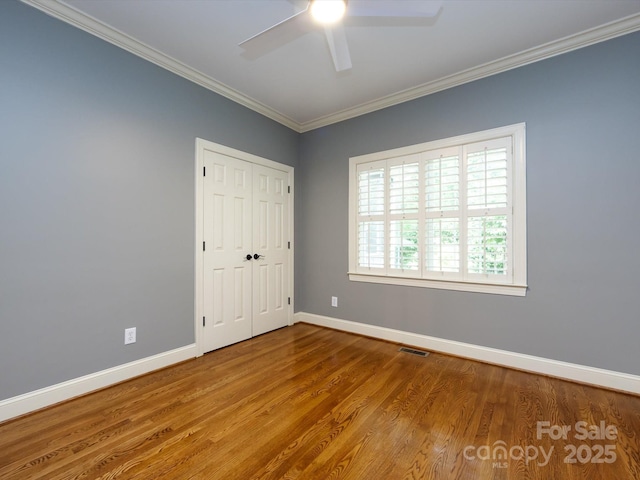5816 Valley Stream Trl, Waxhaw, NC 28173 - unfurnished bedroom with crown molding, baseboards, wood finished floors, a closet, and ceiling fan