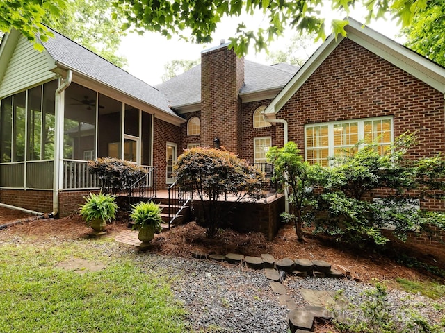5816 Valley Stream Trl, Waxhaw, NC 28173 - back of house with a sunroom, a chimney, roof with shingles, brick siding, and a deck
