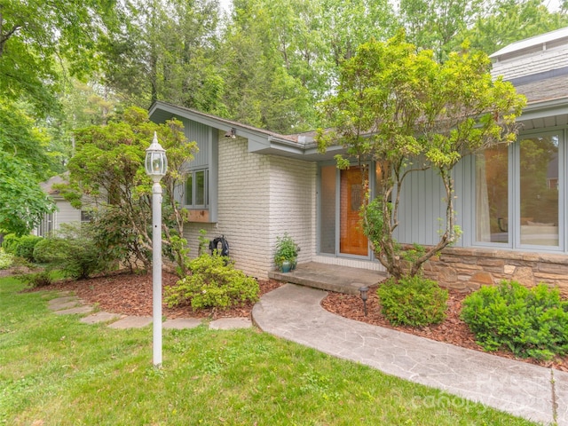6 Browntown Rd, Asheville, NC 28803 - view of front of home featuring brick siding, a front yard, and board and batten siding