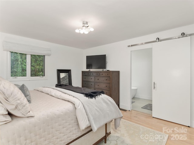 6 Browntown Rd, Asheville, NC 28803 - bedroom with a barn door, light wood-style floors, and ensuite bathroom