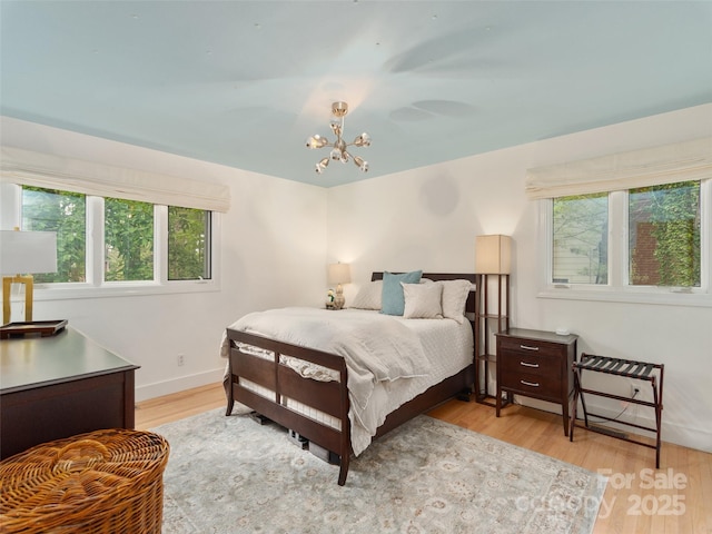 6 Browntown Rd, Asheville, NC 28803 - bedroom featuring multiple windows, light wood-type flooring, a chandelier, and baseboards