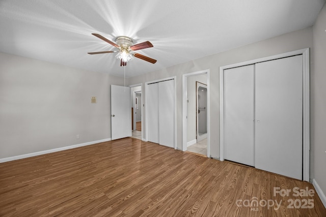 1810 Country Manor Ln Unit 34, Rock Hill, SC 29730 - unfurnished bedroom featuring two closets, wood finished floors, baseboards, ceiling fan, and ensuite bathroom