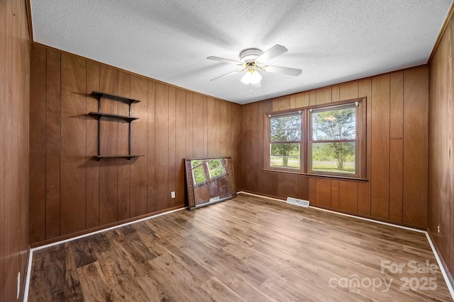 1810 Country Manor Ln Unit 34, Rock Hill, SC 29730 - empty room with a ceiling fan, wood finished floors, wood walls, a textured ceiling, and baseboards