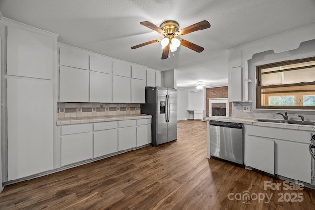 1810 Country Manor Ln Unit 34, Rock Hill, SC 29730 - kitchen featuring appliances with stainless steel finishes, tile counters, ceiling fan, a sink, and dark wood-style flooring