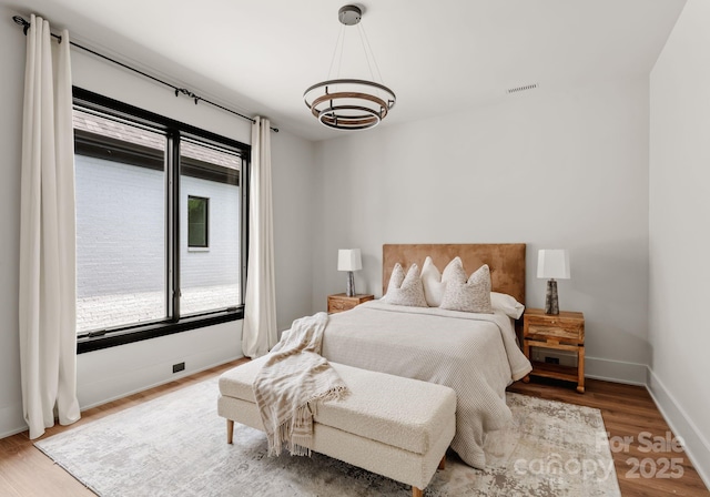 5432 Carmel Rd, Charlotte, NC 28210 - bedroom with a chandelier, wood finished floors, and baseboards