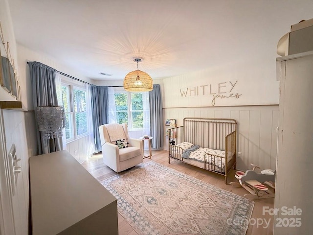3314 Mara Ct, Matthews, NC 28105 - bedroom featuring a nursery area, light wood finished floors, and a wainscoted wall