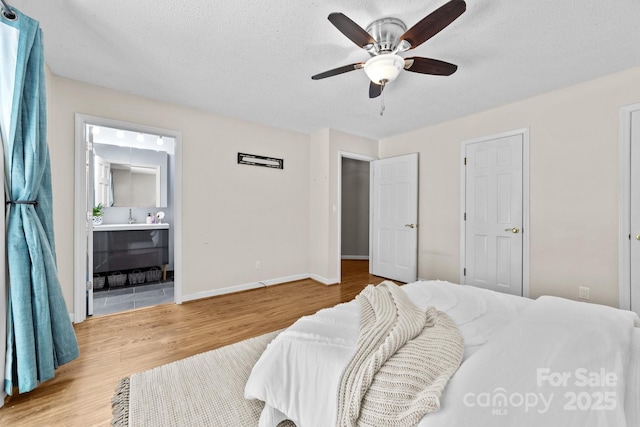 1827 Beckner Rd, Lexington, NC 27292 - bedroom featuring wood finished floors, baseboards, a textured ceiling, ensuite bath, and a ceiling fan