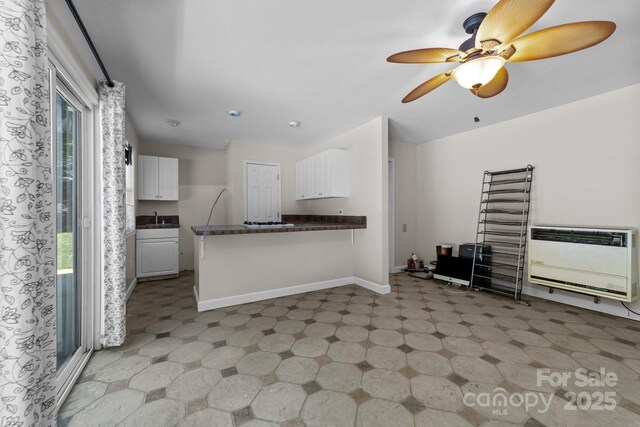 1827 Beckner Rd, Lexington, NC 27292 - kitchen with heating unit, dark countertops, light floors, and white cabinetry