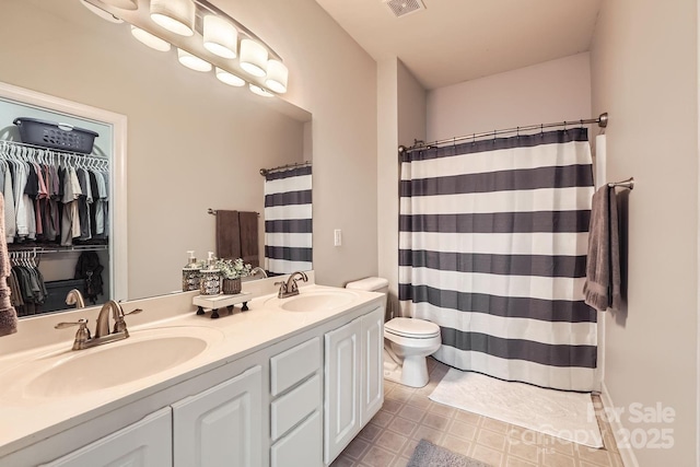 18605 Ruffner Dr Unit 3E, Cornelius, NC 28031 - bathroom featuring toilet, double vanity, curtained shower, and a walk in closet
