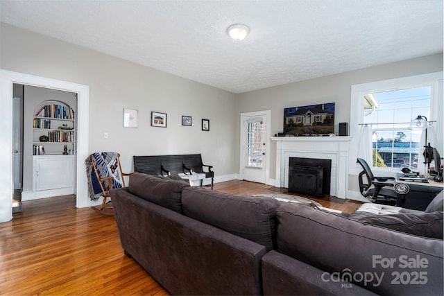 98 S Main St, Granite Falls, NC 28630 - living area featuring a fireplace with flush hearth, a textured ceiling, plenty of natural light, and wood finished floors
