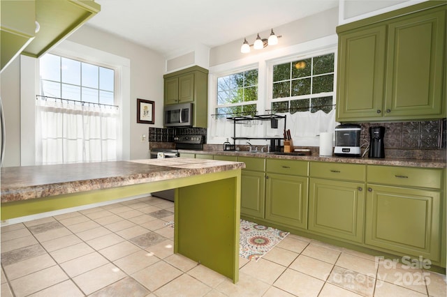 98 S Main St, Granite Falls, NC 28630 - kitchen with stainless steel appliances, decorative backsplash, green cabinetry, light tile patterned floors, and a sink