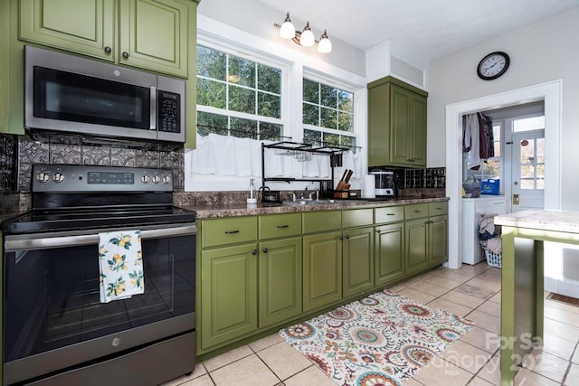 98 S Main St, Granite Falls, NC 28630 - kitchen featuring appliances with stainless steel finishes, green cabinets, tasteful backsplash, a sink, and light tile patterned floors