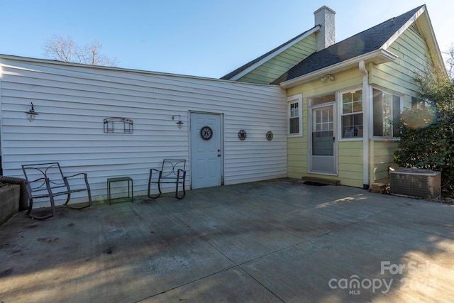 98 S Main St, Granite Falls, NC 28630 - rear view of property featuring central AC unit, a patio area, and a chimney