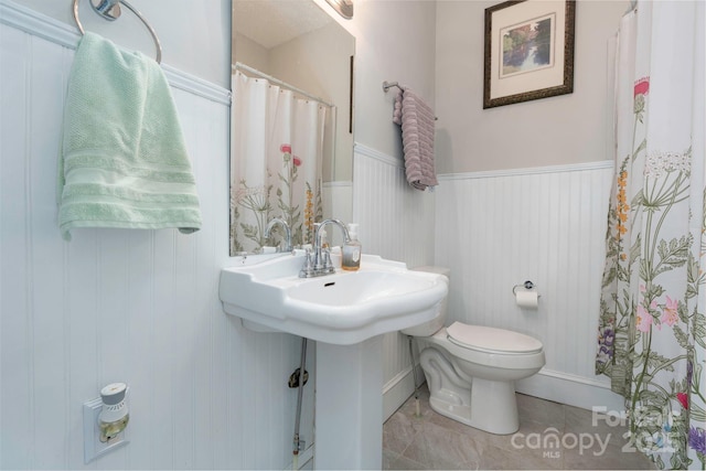 98 S Main St, Granite Falls, NC 28630 - bathroom featuring toilet, wainscoting, and a shower with shower curtain