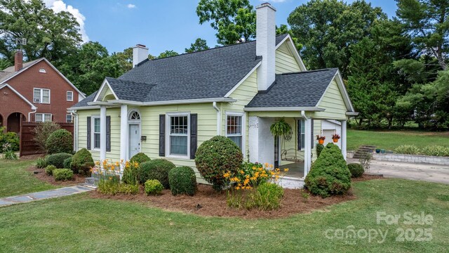 98 S Main St, Granite Falls, NC 28630 - view of front of house featuring a front yard, a shingled roof, a chimney, and covered porch