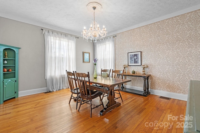 98 S Main St, Granite Falls, NC 28630 - dining space with a textured ceiling, wallpapered walls, a chandelier, and light wood-style floors