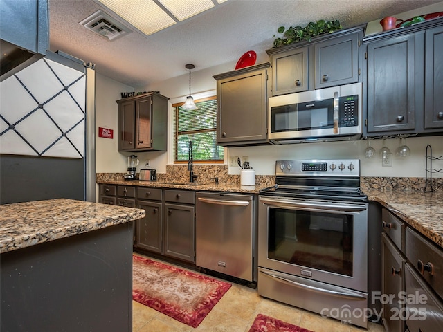 128 Quail Run Ct Unit 1627, Lake Lure, NC 28746 - kitchen featuring stainless steel appliances, light stone countertops, a sink, decorative light fixtures, and a textured ceiling