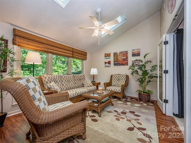 128 Quail Run Ct Unit 1627, Lake Lure, NC 28746 - living room with vaulted ceiling, wood finished floors, a ceiling fan, a skylight, and baseboards