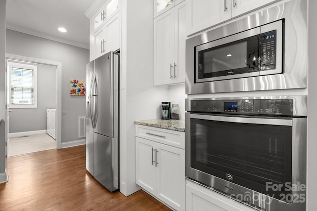 73 41st Ave NW, Hickory, NC 28601 - kitchen with appliances with stainless steel finishes, glass insert cabinets, light stone counters, baseboards, and estacked washer and dryer