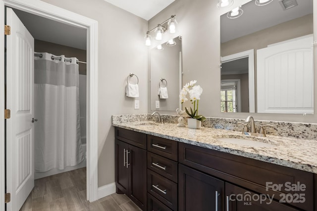 73 41st Ave NW, Hickory, NC 28601 - full bath with double vanity, baseboards, a shower with curtain, and wood finished floors