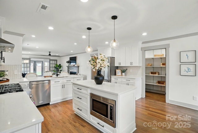 343 Melbourne Ct, Charlotte, NC 28209 - kitchen with stainless steel appliances, decorative backsplash, light countertops, a peninsula, and recessed lighting
