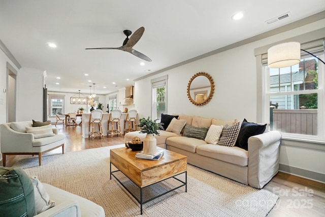 343 Melbourne Ct, Charlotte, NC 28209 - living room with a ceiling fan, light wood-style floors, recessed lighting, crown molding, and a chandelier