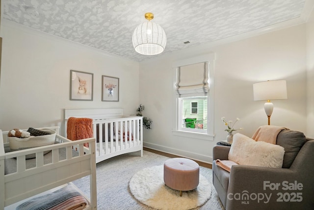 343 Melbourne Ct, Charlotte, NC 28209 - bedroom featuring a crib, baseboards, wood finished floors, and ornamental molding