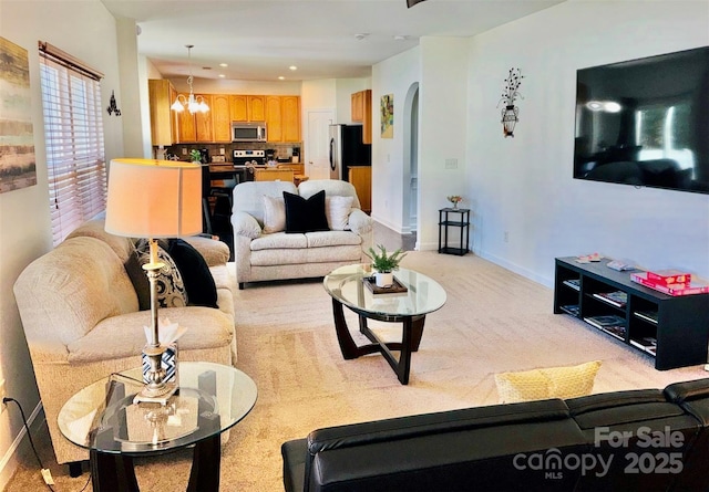 435 Riverwalk Dr NW, Concord, NC 28027 - living room with a chandelier, arched walkways, baseboards, light colored carpet, and recessed lighting
