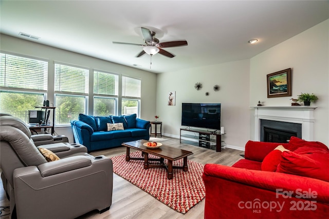 6038 Durango Way, Denver, NC 28037 - living room featuring ceiling fan, light wood-type flooring, a glass covered fireplace, and baseboards