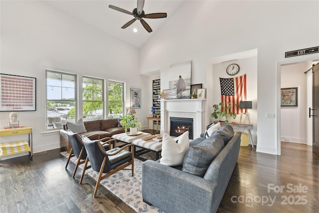 164 Twin Sisters Ln, Mooresville, NC 28117 - living room with ceiling fan, high vaulted ceiling, baseboards, a lit fireplace, and dark wood-style flooring
