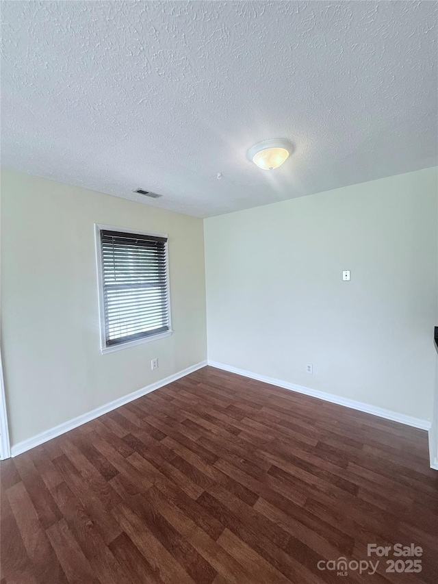 300 N Watterson St, Kings Mountain, NC 28086 - spare room with dark wood-type flooring, a textured ceiling, and baseboards