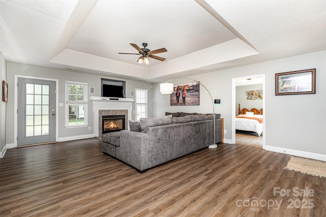 1626 Riverglenn Ct, Rock Hill, SC 29732 - living area featuring a tray ceiling, baseboards, ceiling fan, wood finished floors, and a tile fireplace