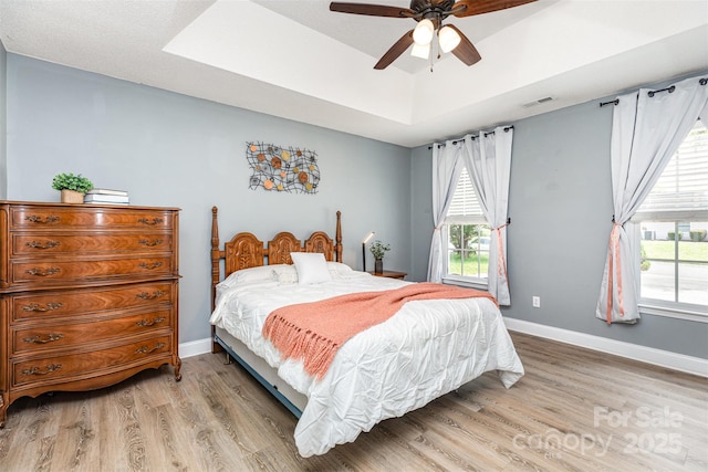 1626 Riverglenn Ct, Rock Hill, SC 29732 - bedroom with light wood-style floors, a tray ceiling, baseboards, and a ceiling fan