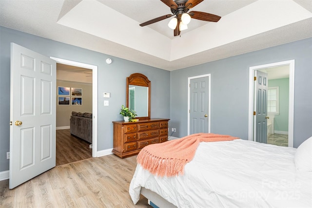 1626 Riverglenn Ct, Rock Hill, SC 29732 - bedroom featuring light wood-type flooring, a tray ceiling, baseboards, connected bathroom, and a ceiling fan