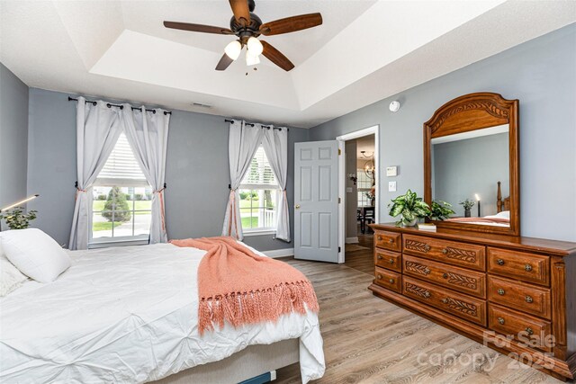 1626 Riverglenn Ct, Rock Hill, SC 29732 - bedroom with a tray ceiling, light wood-style flooring, a ceiling fan, and baseboards