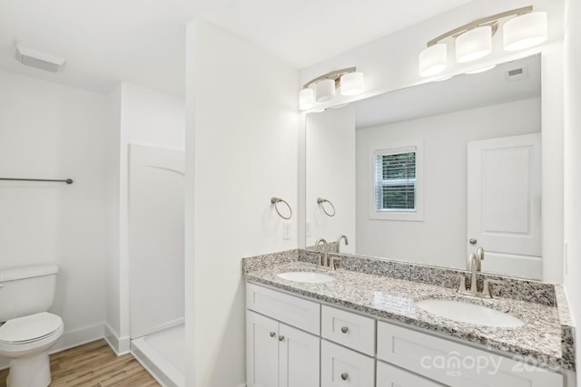 401 W Charlotte Ave, Mount Holly, NC 28120 - bathroom featuring double vanity, toilet, wood finished floors, a shower, and baseboards