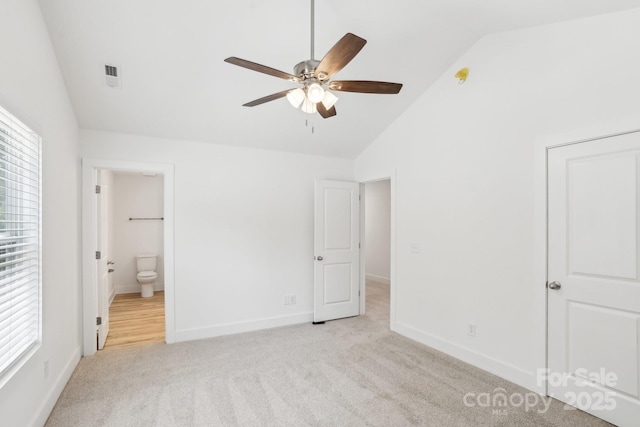 401 W Charlotte Ave, Mount Holly, NC 28120 - unfurnished bedroom with light colored carpet, connected bathroom, baseboards, ceiling fan, and high vaulted ceiling