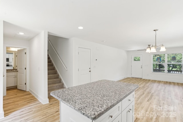 401 W Charlotte Ave, Mount Holly, NC 28120 - kitchen with light wood-style floors, baseboards, light stone counters, a chandelier, and open floor plan