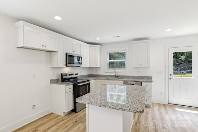 401 W Charlotte Ave, Mount Holly, NC 28120 - kitchen with appliances with stainless steel finishes, a sink, light wood-type flooring, light stone countertops, and baseboards