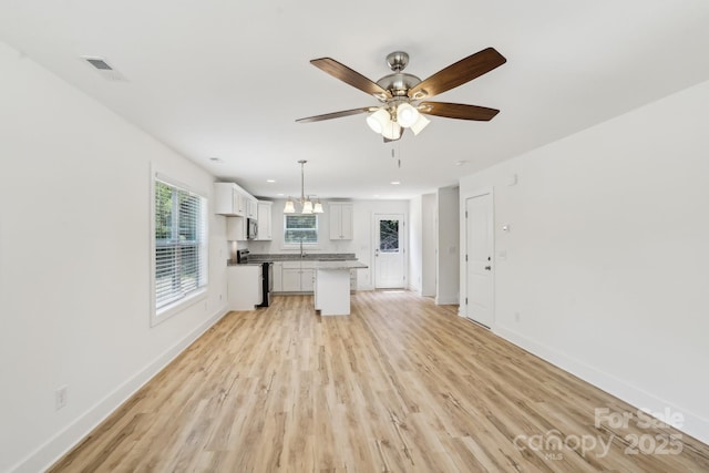 401 W Charlotte Ave, Mount Holly, NC 28120 - kitchen with stainless steel appliances, white cabinets, light wood-style floors, a ceiling fan, and baseboards