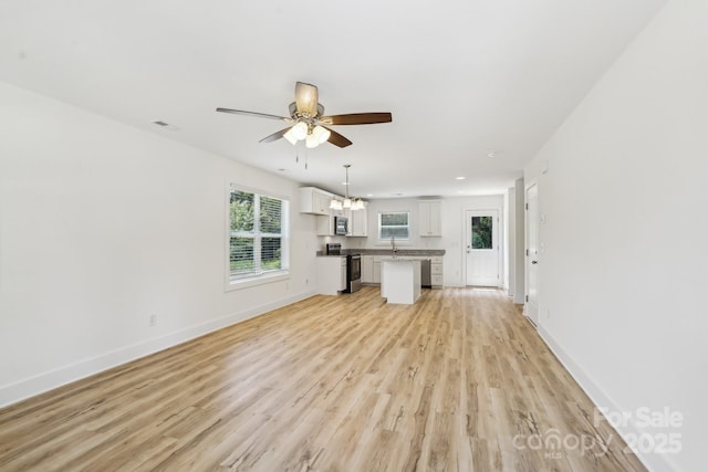 401 W Charlotte Ave, Mount Holly, NC 28120 - unfurnished living room featuring light wood-style floors, a chandelier, baseboards, and a ceiling fan
