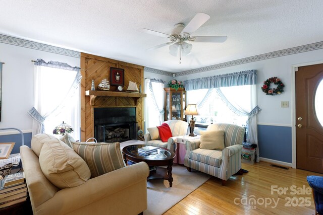 517 Powell St, Rock Hill, SC 29732 - living room with wood finished floors, a textured ceiling, ceiling fan, baseboards, and a fireplace