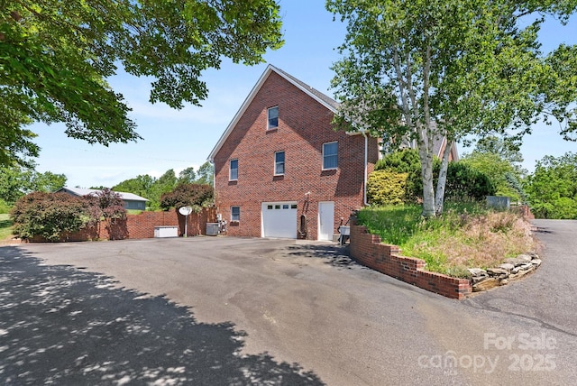 250 Huey Rd, Marshall, NC 28753 - view of property exterior featuring brick siding, a garage, and asphalt driveway