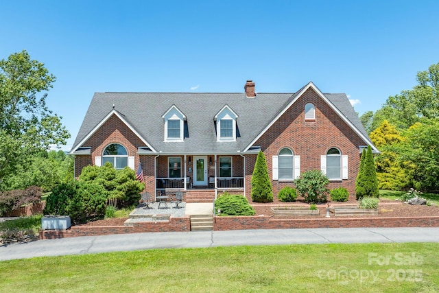 250 Huey Rd, Marshall, NC 28753 - cape cod-style house featuring brick siding, covered porch, a chimney, and a front lawn